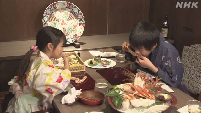 Hai khách hàng nhí thưởng thức cua tuyết một cách ngon lành/ Photo: NHK